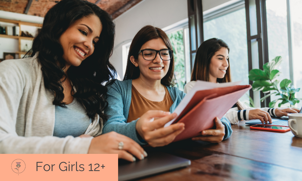 Woman and two girls sitting at table together From left: Hispanic woman with dark curly hair looks at a folder the girl next to her is holding. Hispanic teenage girl with blue cardigan and orange shirt wearing glasses looking at a pink folder with papers. In distance, another teenage girl looks at computer. On the bottom left, the words "For Girls 12+" and the Pearl and Thistle logo appear on an orange background.