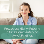 young girls sits on a couch smiling. text reads "precocious early puberty in girls: commentary on JAMA findings"